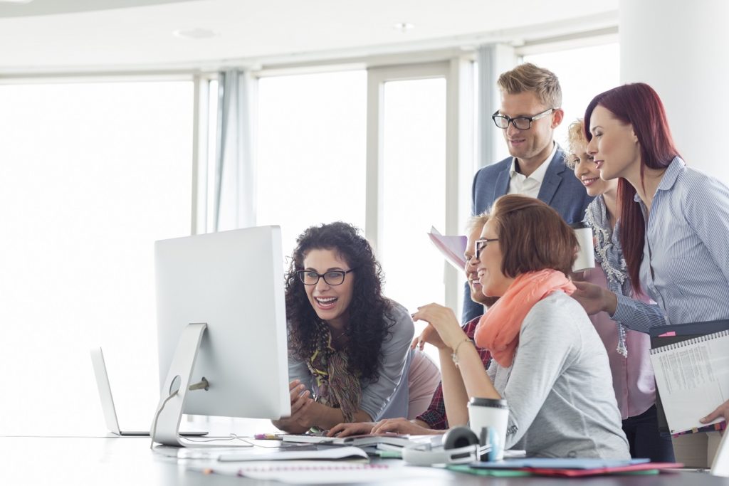 Smiling businesspeople working together at conference table